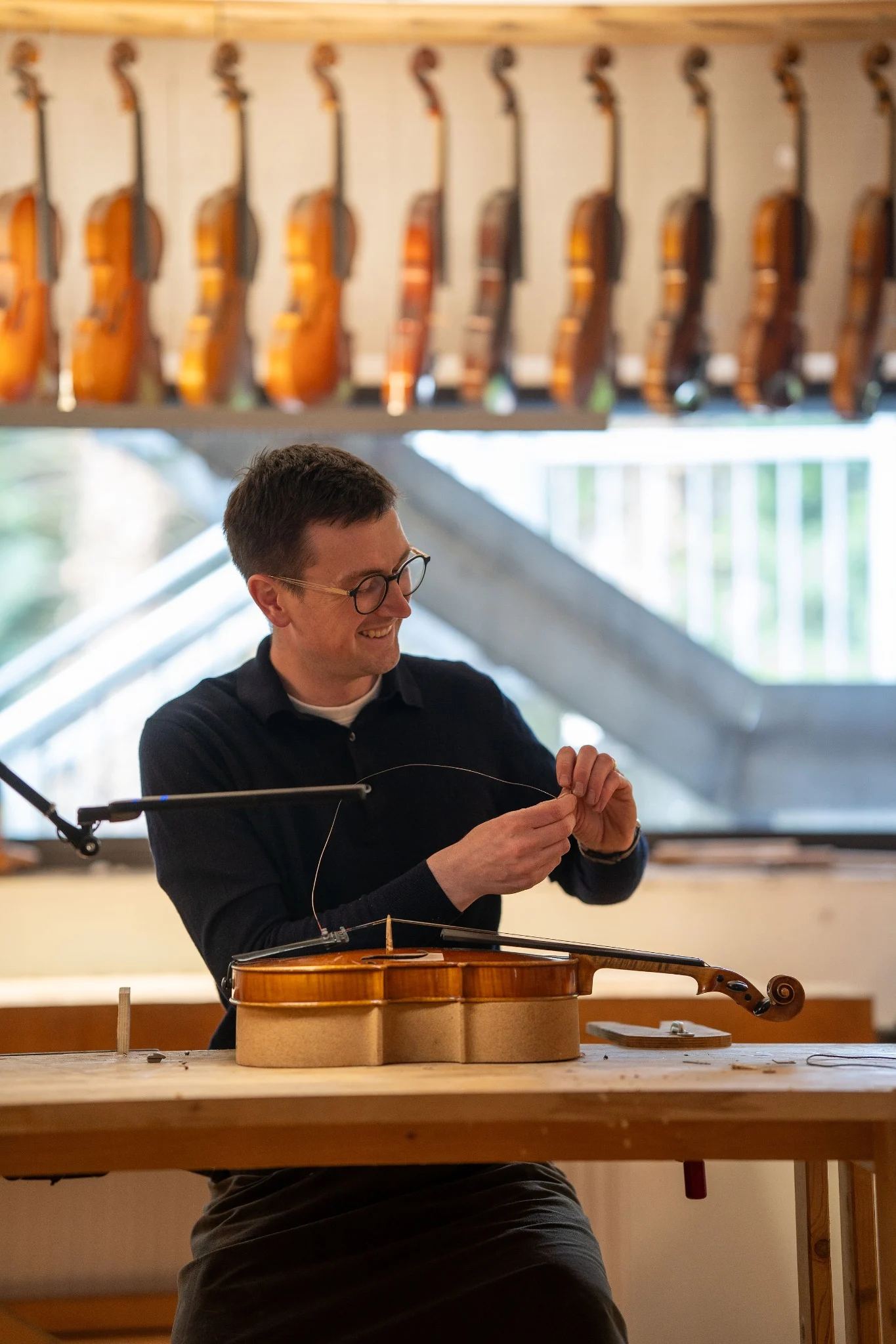 Charles W. G. Cousins bei Restaurierungsarbeiten an einem Streichinstrument